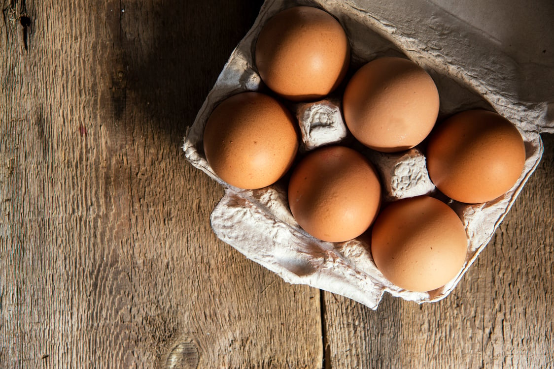 Fresh eggs in egg box in natural lighting vintage style